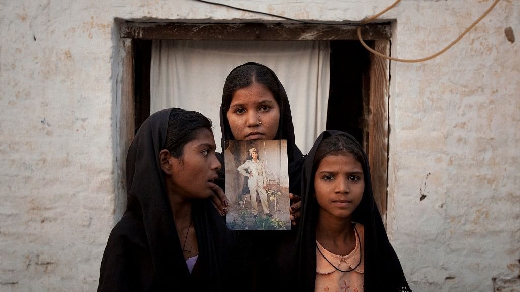 Aasia Bibi’s daughters hold an image of their mother outside their residence in Sheikhupura, located in Pakistan’s Punjab province, on 13 November 2010.&nbsp;