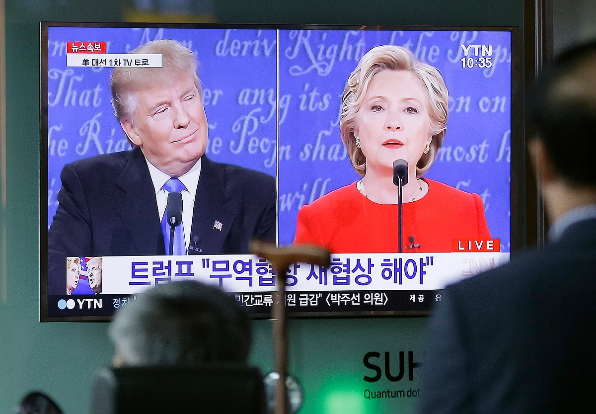 People watch a TV screen showing the live broadcast of the US presidential debate between Hillary Clinton and Donald Trump. (Photo: AP)