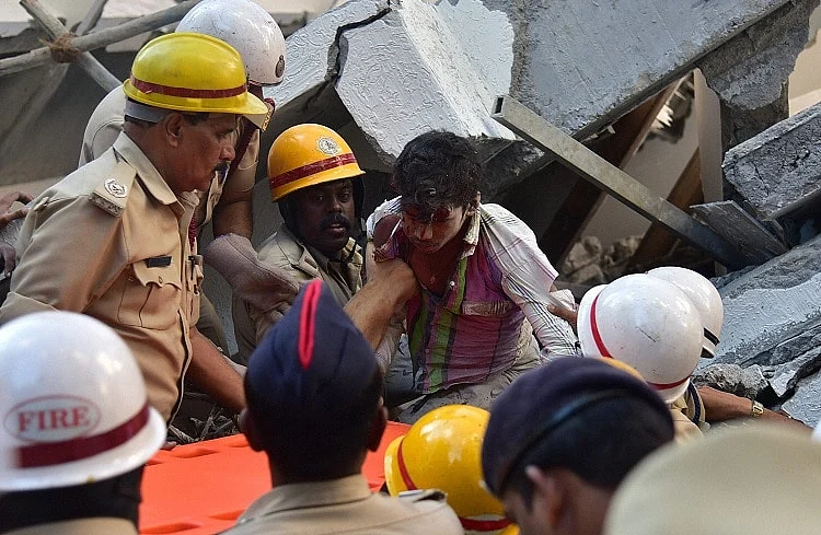 Police rescue a labourer stuck in debris. (Photo Courtesy: <i>The News Minute</i>)