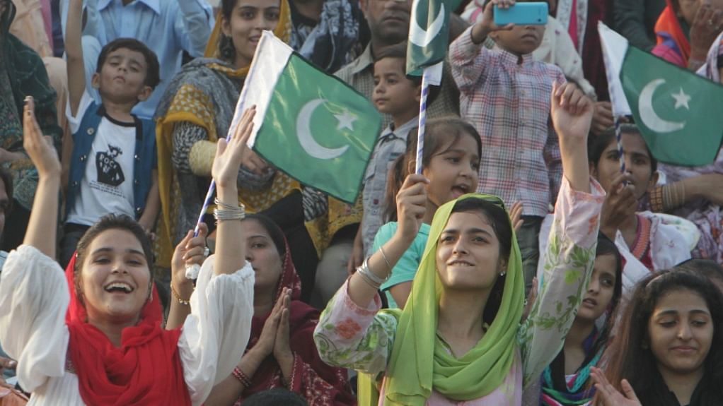 Pakistani spectators wave their national flags during a daily border closing ceremony at the Wagah border post in Pakistan. (Photo: AP)