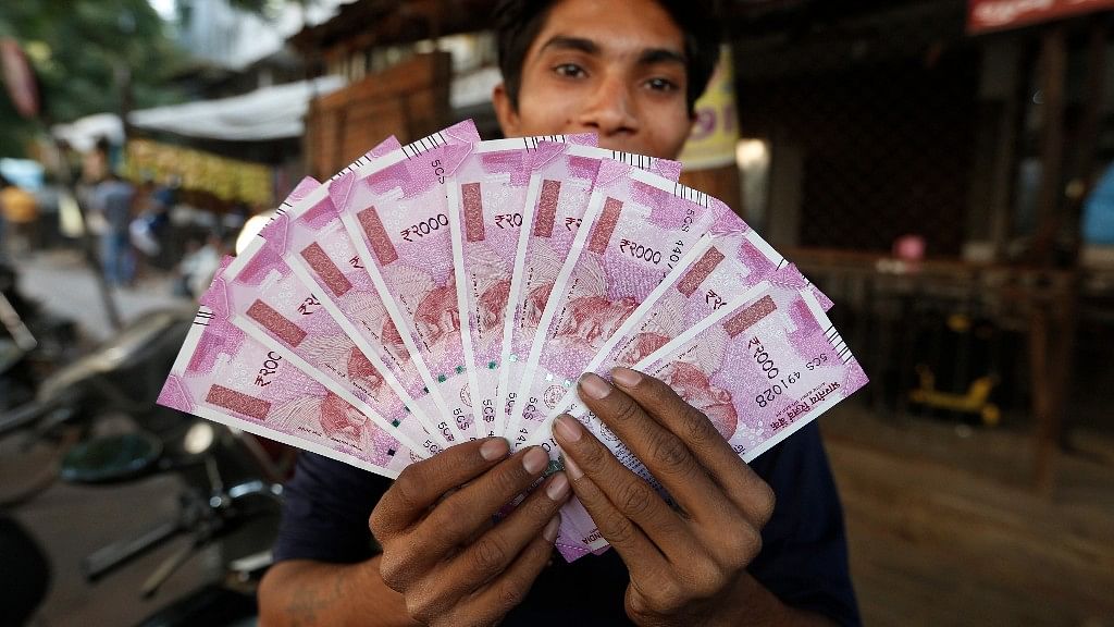 File photo of an Indian man displaying new Rs 2,000 notes in Ahmadabad, India.&nbsp;