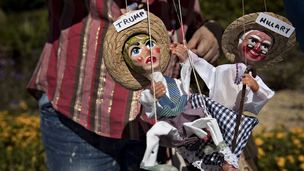  A demonstrator holds marionettes of Donald Trump, 2016 Republican presidential nominee, and Hillary Clinton, 2016 Democratic presidential nominee. (Photographer: Andrew Harrer/Bloomberg)