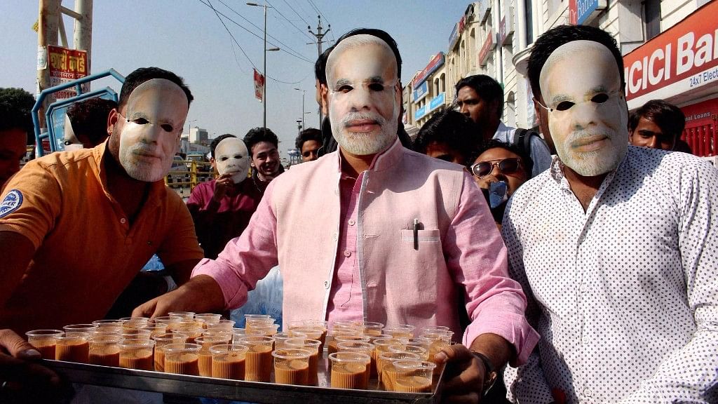 

BJYM workers wearing masks of Prime Minister Narendra Modi serve tea to  people queuing up outside Banks and ATMs   in Bhopal, 15 November 2016. (Photo: PTI)