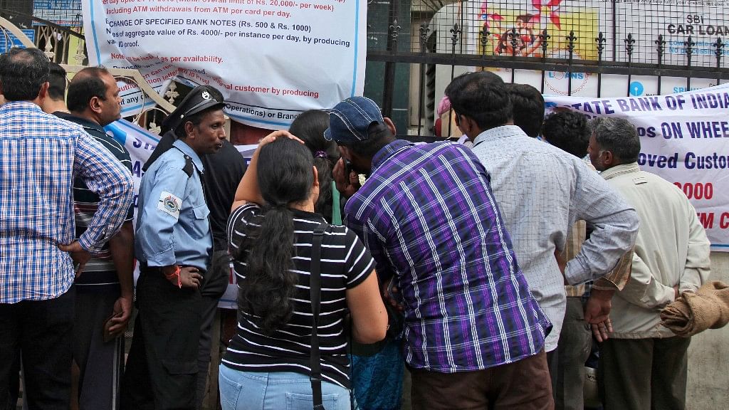 Indians stand in a queue to withdraw money by swiping their debit cards outside a State Bank of India branch in Hyderabad. (Photo: AP)