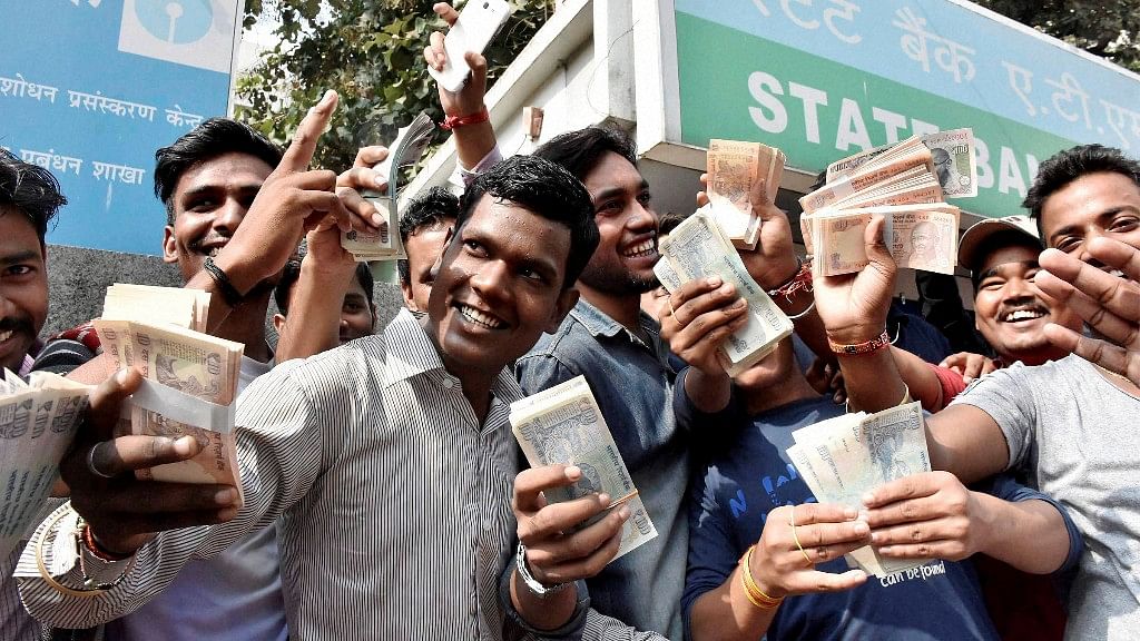  People showing their money after withdrawing from an ATM after a long queue in Patna on Sunday. (Photo: PTI)  &nbsp;