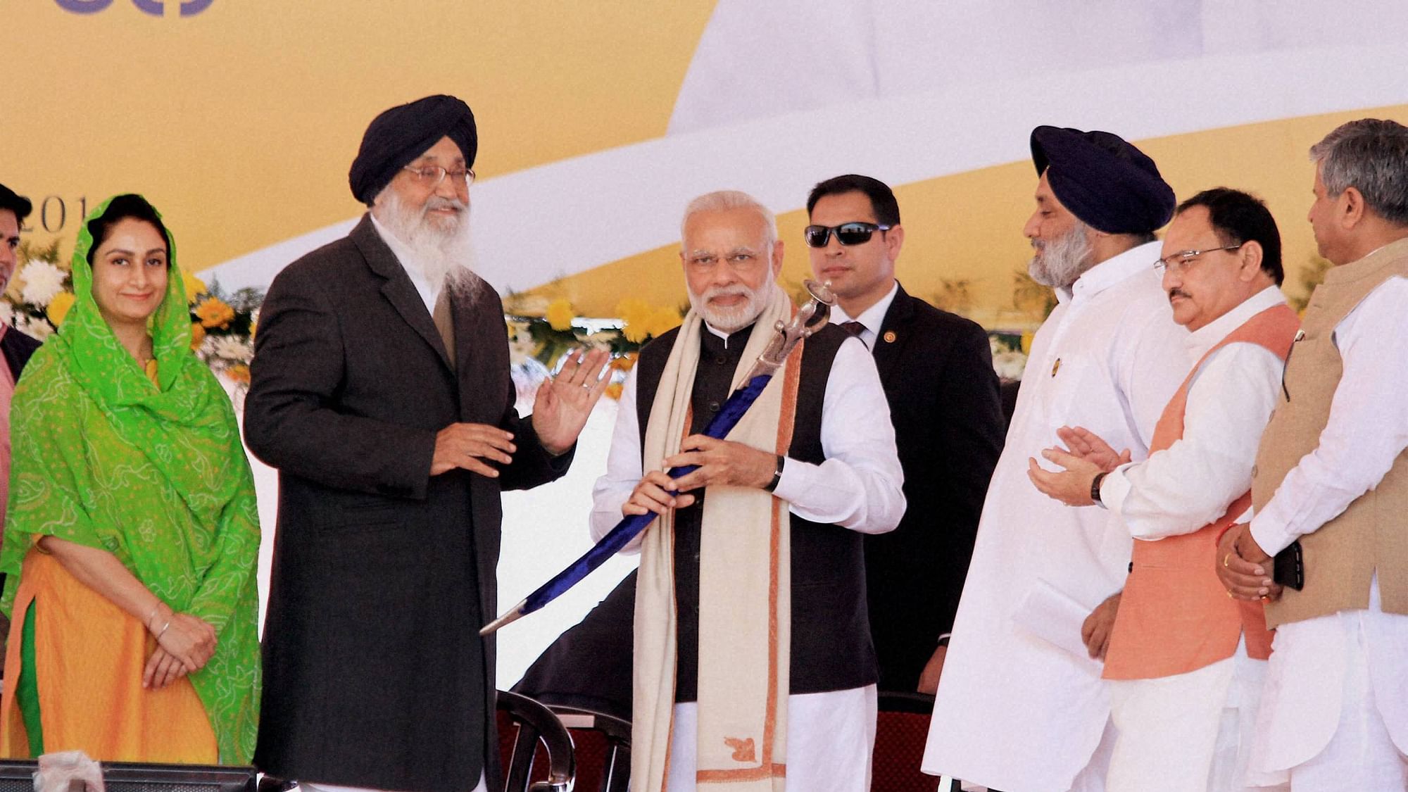 Prime Minister Narendra Modi is presented a sword by Punjab CM Parkash Singh Badal in Bathinda as Union Ministers JP Nadda, Harsimrat Kaur watch on.&nbsp;
