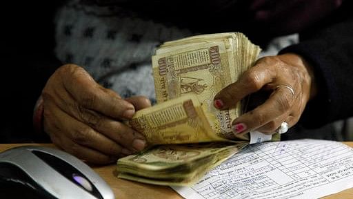 In this 16 December 2011 file photo, a cashier counts Indian rupee bank notes at a bank in Allahabad, India (Photo: AP) 