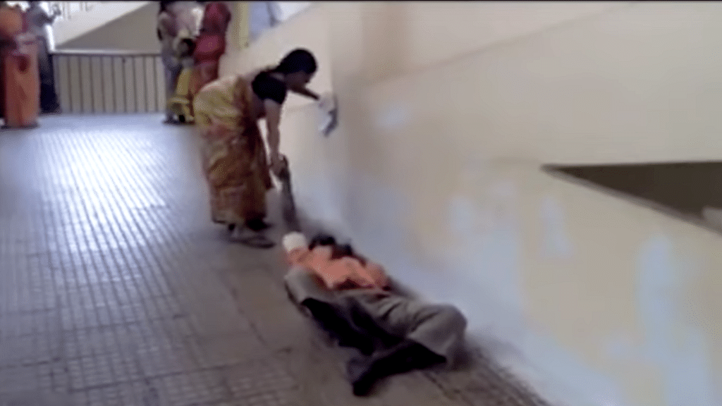 A woman drags her husband up the ramp in an Andhra Pradesh hospital. (Photo: Youtube screenshot)