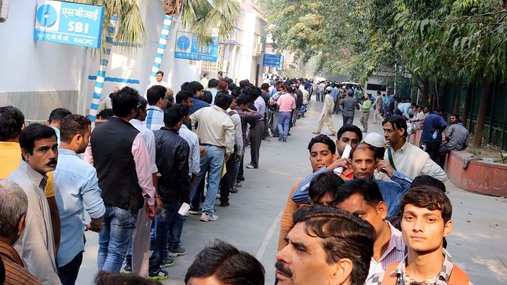 

People queue up in front of ATMs  in New Delhi. (Photo: IANS)