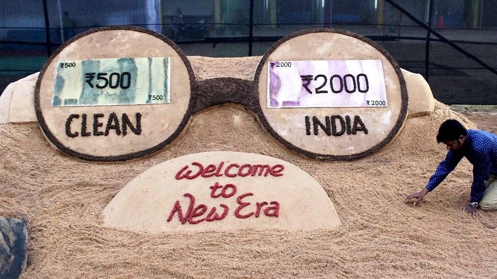 Sand artist Sudarsan Pattnaik makes a sand sculpture on the new currency notes and demonetisation. (Photo: PTI)   