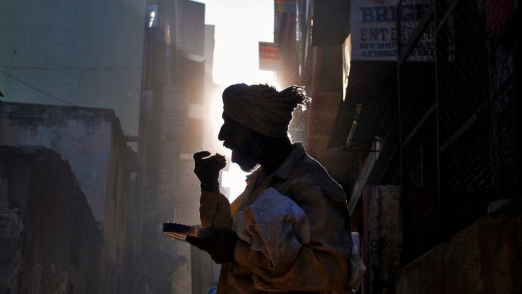 A homeless man eats his breakfast on a street in Bengaluru. (Photo: Reuters/Abhishek N. Chinnappa)