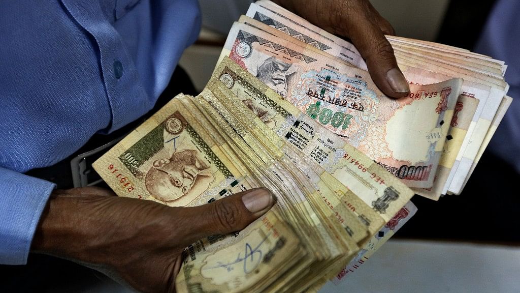 An Indian man sorts Rs 1,000 and Rs 500  currency notes at a fuel pump in Ahmadabad, India. (Photo: AP)