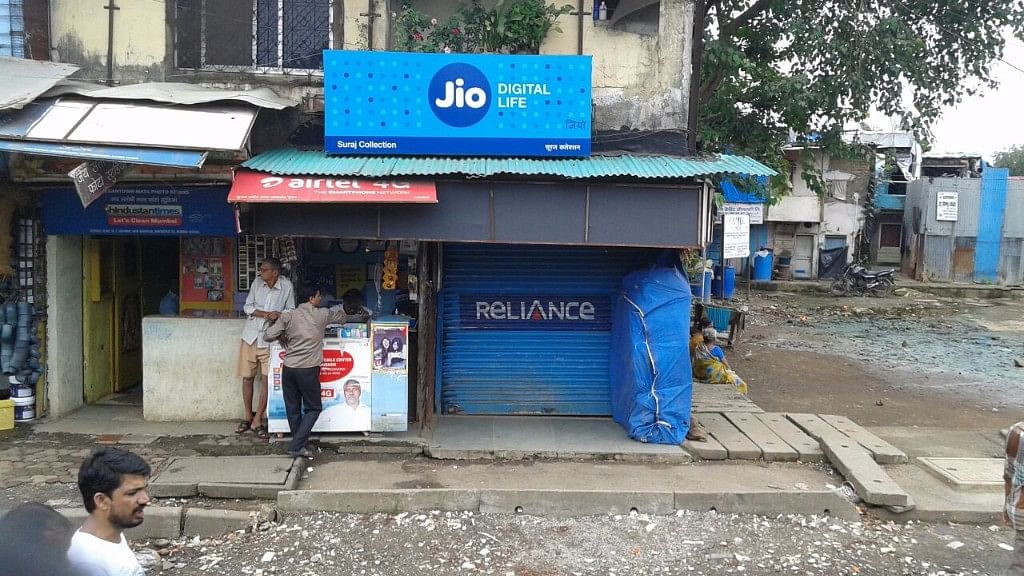 

Reliance Jio’s advertisement is visible on a board above Airtel’s logo outside a store in Mumbai. (Photographer: Vishal Patel/Bloomberg)