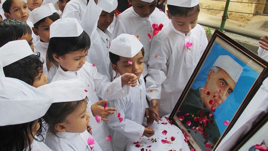 Children dressed up as Chacha Nehru pay floral tribute to Jawaharlal Nehru on the eve of his  birth anniversary in Allahabad. (Photo Courtesy: PTI)