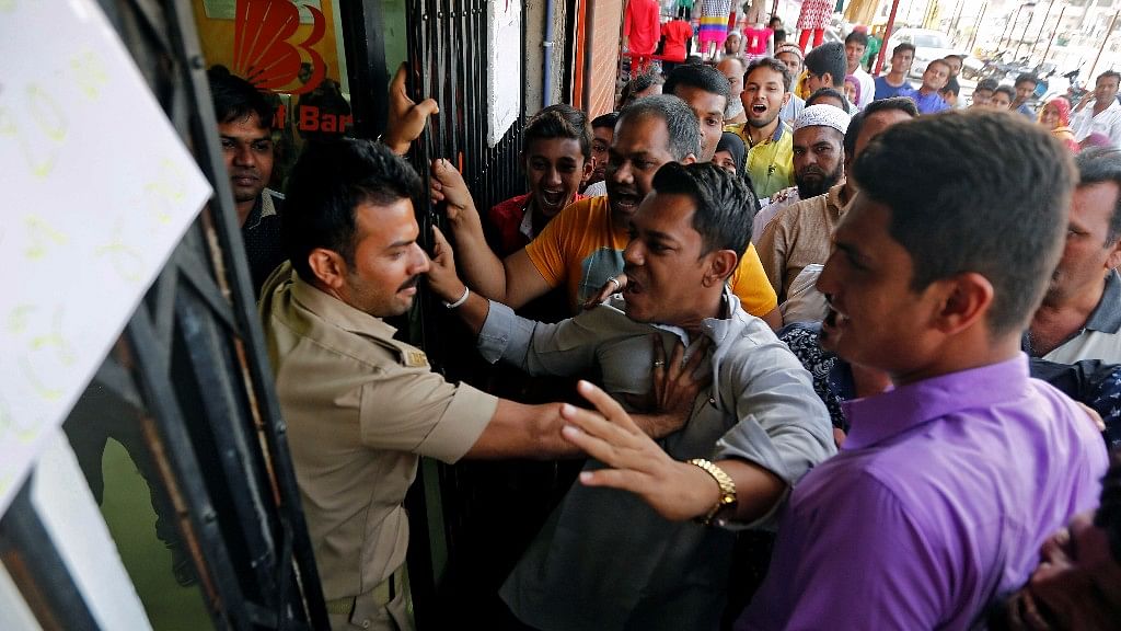 People scuffle with a policeman outside a bank. Image only used for representational purposes. (Photo: Reuters)