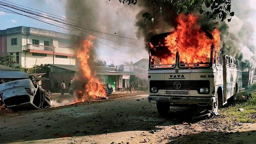 Angry mobs set vehicles on fire in Imphal East district on Sunday in protest against the United Naga Council (UNC)‘s indefinite economic blockade. (Photo: PTI)