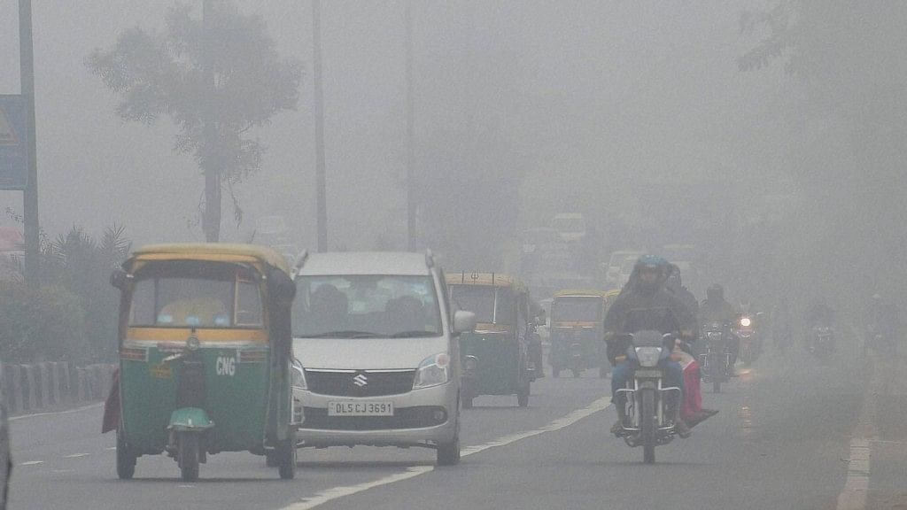 Vehicles move through dense fog in New Delhi on Wednesday. (Photo: PTI)
