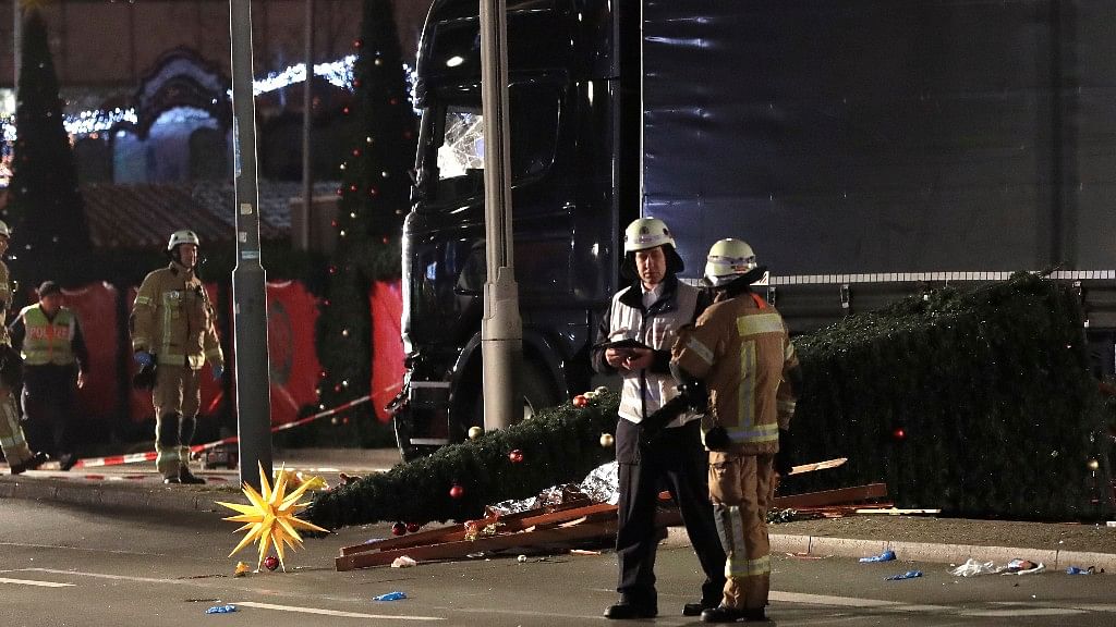 Firefighters stand beside a toppled Christmas tree after a truck ran into a crowded Christmas market and killed several people in Berlin, Germany late on Monday evening. (Photo: AP)