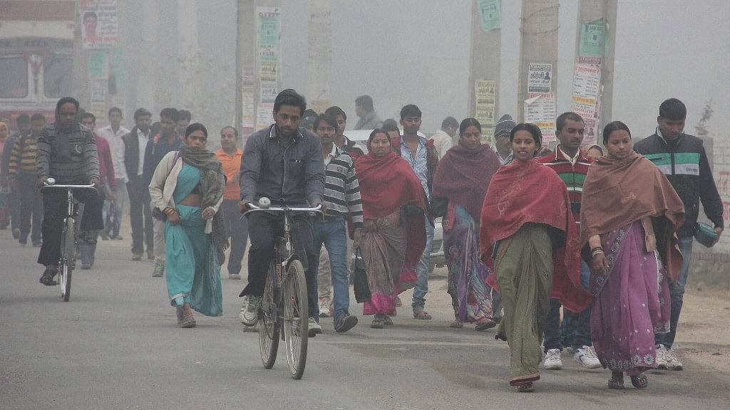 People wear warm clothes to protect themselves from cold on a foggy morning in Gurugram on Thursday. (Photo: PTI)