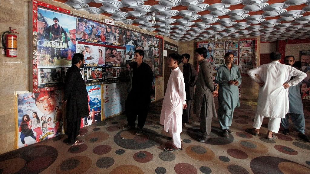 Pakistani cinema-goers look at photos displayed at a local cinema in Karachi, Pakistan, Sunday, 18 December 2016.  (Photo: AP)
