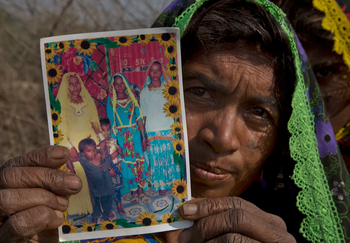 Ameri Kashi Kolhi shows picture of her daughter Jeevti, right, in Payro Lundh, Pakistan.(Photo: AP)