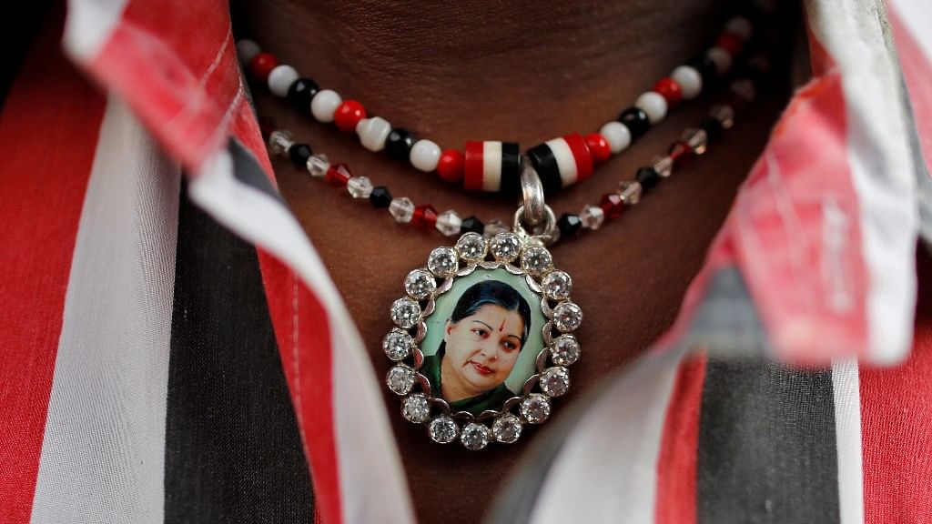 A supporter of Jayalalithaa wears a necklace with her picture as he attends a prayer ceremony at the AIADMK party office. (Photo: Reuters)