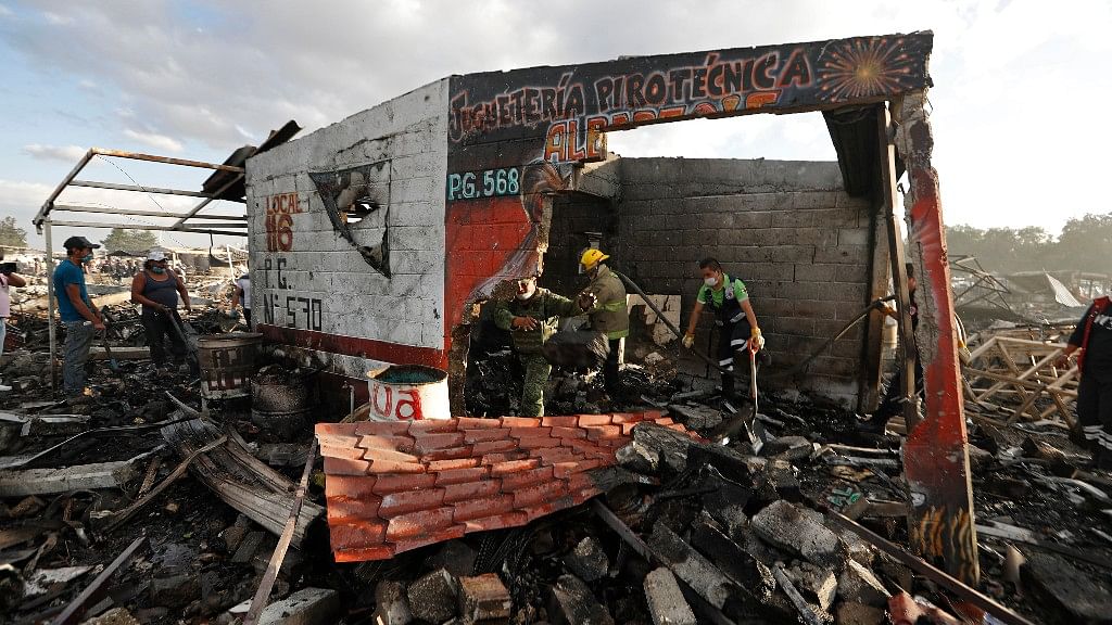 

Firefighters and rescue workers remove debris from the scorched ground of Mexico’s fireworks market after explosion. (Photo: AP)