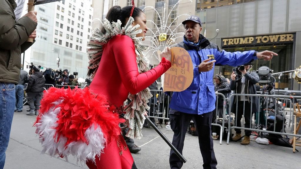 A New York City Police Dept officer asks anti-Donald Trump protestor Marni Halasa to move as she demonstrates across Fifth Avenue from Trump Tower in New York. (Photo: AP)