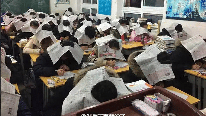 With the newspaper on the heads, their eyes are restricted to their papers and others are also prevented from looking at their papers. (Photo Courtesy: Twitter/<a href="https://twitter.com/mutazdoceo">‏@<b>mutazdoceo</b></a>)
