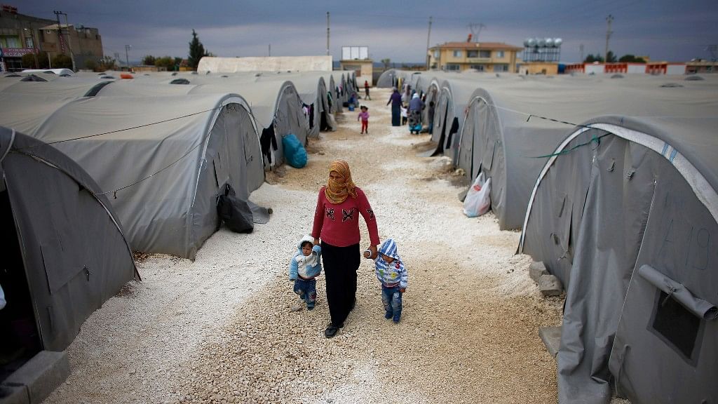  A Kurdish refugee woman, from the Syrian town of Kobanî, walks with her children at a refugee camp in the border town of Suruç, Şanliurfa province. (Photo: Reuters)
