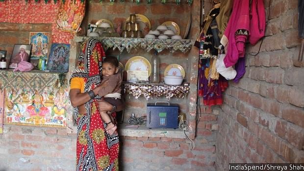 Rajwati stands near the solar energy meter, inside her house in the village of Dhubiya, Uttar Pradesh. She uses solar energy to power three lights and one fan in her house. (Photo Courtesy: IndiaSpend/Shreya Shah).