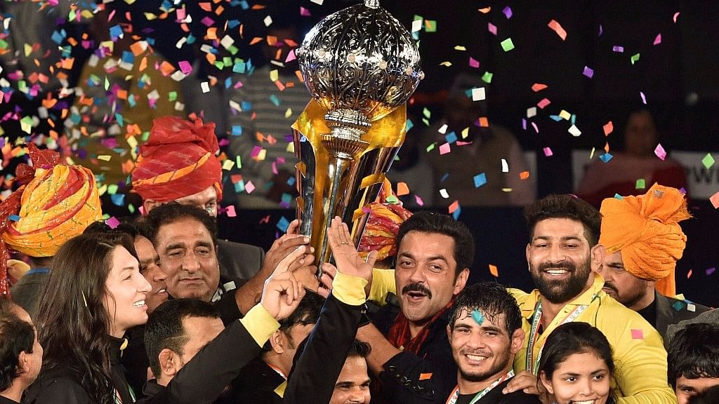 Punjab Royals’ co-owner Bobby Deol and players celebrate with Pro Wrestling League Season 2 Trophy after they beat Haryana Hammers in the final. (Photo: PTI)