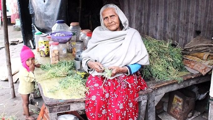  75-year-old Afsa Begum sells biscuits and fryums for kids in Patna, Bihar, where she, her daughter-in-law and two-year-old granddaughter have squatted for years. Her husband is dead and her son left for Mangalore to work for a construction contractor after the severe monsoon floods in 2016. He has sent money only once. (Photo by Manipadma Jena)