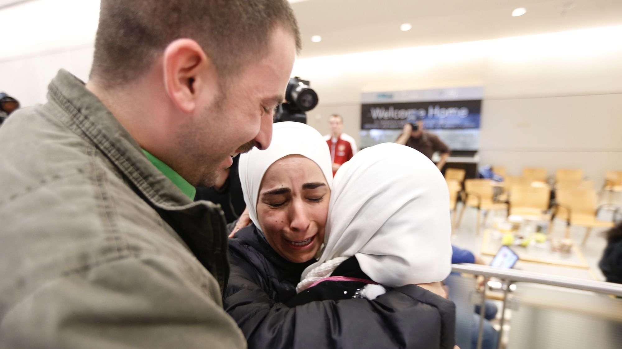 Hisham (left) and Mariam Yasin (center) welcome their mother Najah Alshamieh from Syria after immigration authorities released her at Dallas Fort Worth Airport on January 28 2017.  (Photo: AP)