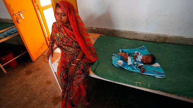 Seven-month-old Deepak, suffering from severe malnutrition, lies on a bed as his mother waits in Lalitpur district, Uttar Pradesh.(Photo: Reuters/Reinhard Krause)
