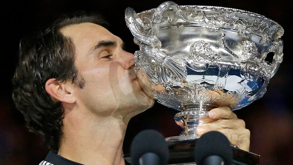 Roger Federer kisses the Australian Open trophy after beating Rafael Nadal in the final. (Photo: AP)