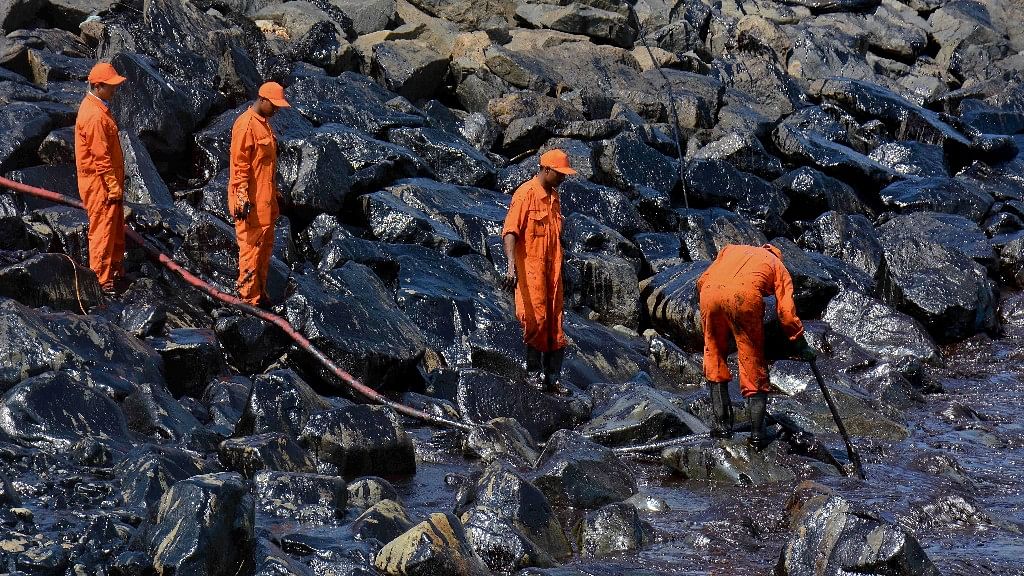 Indian Coast Guard personnel work to clear the slick after an oil spill polluted the Ennore beach on the Bay of Bengal coast near Chennai. (Photo: AP)
