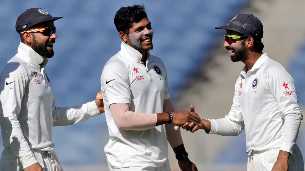 India’s Umesh Yadav, center celebrates a wicket with Virat Kohli, left and Ajinkya Rahane during the first day of the first Test against Australia at Pune on Thursday. (Photo: AP)
