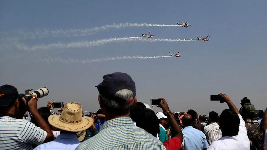 Spectators watch indigenously manufactured Indian Air Force Dhruv helicopters perform aerobatic manoeuvres on the fourth day of Aero India 2017 at Yelahanka air base in Bengaluru. <a></a>