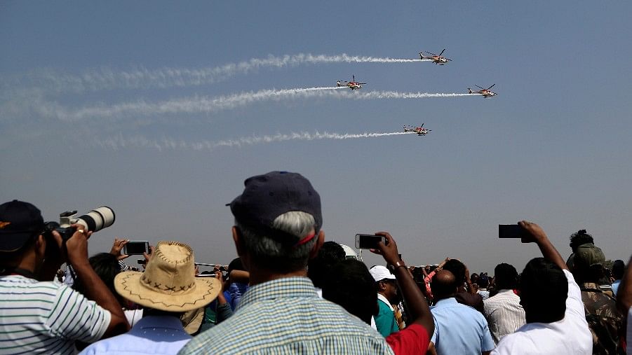 Spectators watch indigenously manufactured Indian Air Force Dhruv helicopters performing aerobatic manoeuvres on the fourth day of Aero India 2017 at Yelahanka air base in Bengaluru. (Photo: AP)<a></a>