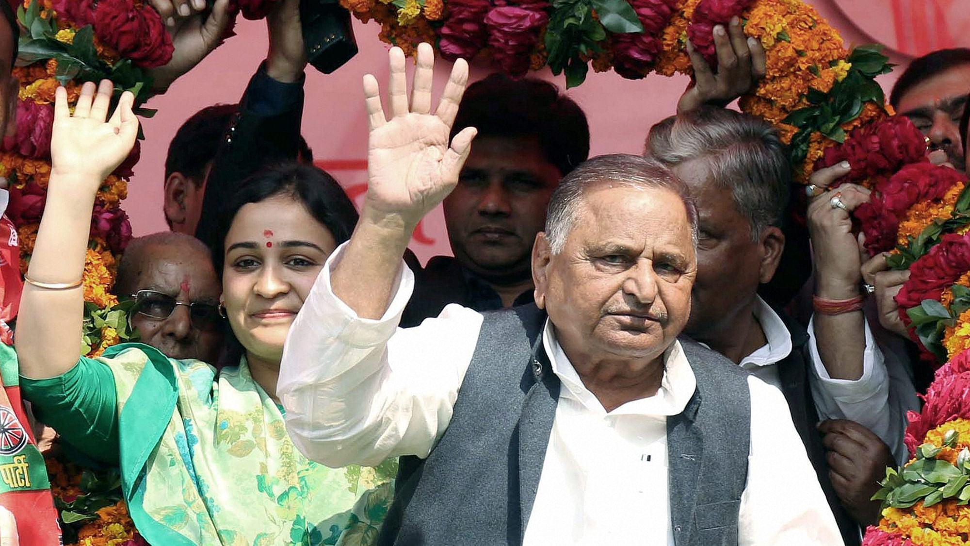 Mulayam Singh Yadav and Aparna Yadav wave at supporters in Lucknow on Wednesday. (Photo: PTI)