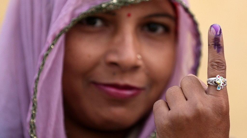 A woman displays her ink marked finger after voting during the state assembly election. (Photo: Reuters)