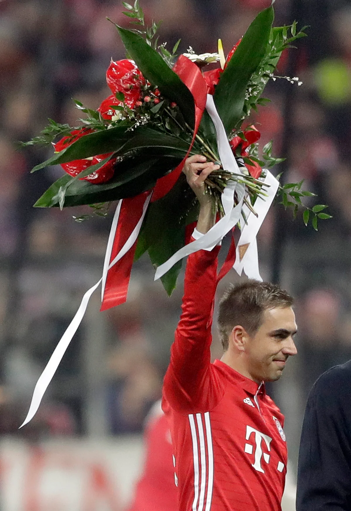 Bayern’s Philipp Lahm waves on the field with flowers prior to the German Soccer Cup match between FC Bayern Munich and VfL Wolfsburg at the Allianz Arena stadium in Munich. (Photo: AP)