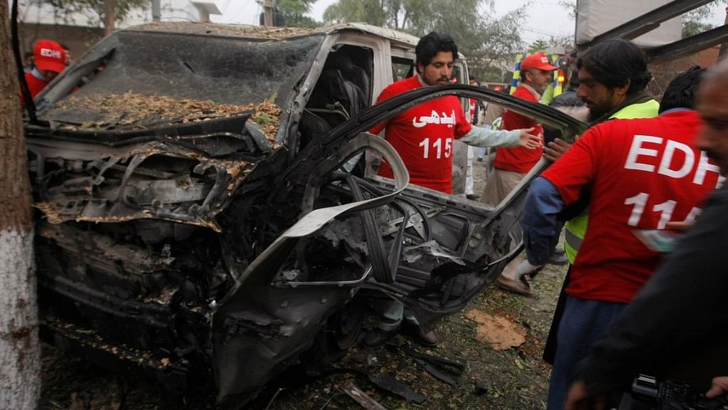 Pakistani volunteers search a vehicle targeted by a bomber. (Photo Courtesy: AP)  