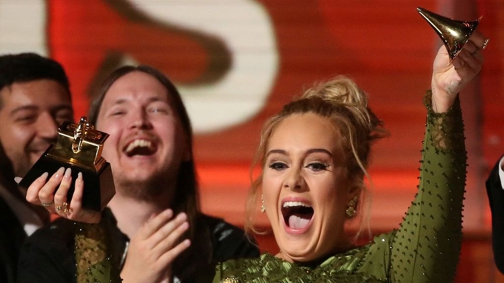 Adele cheers with her Grammy broken into  half. (Photo: Reuters)