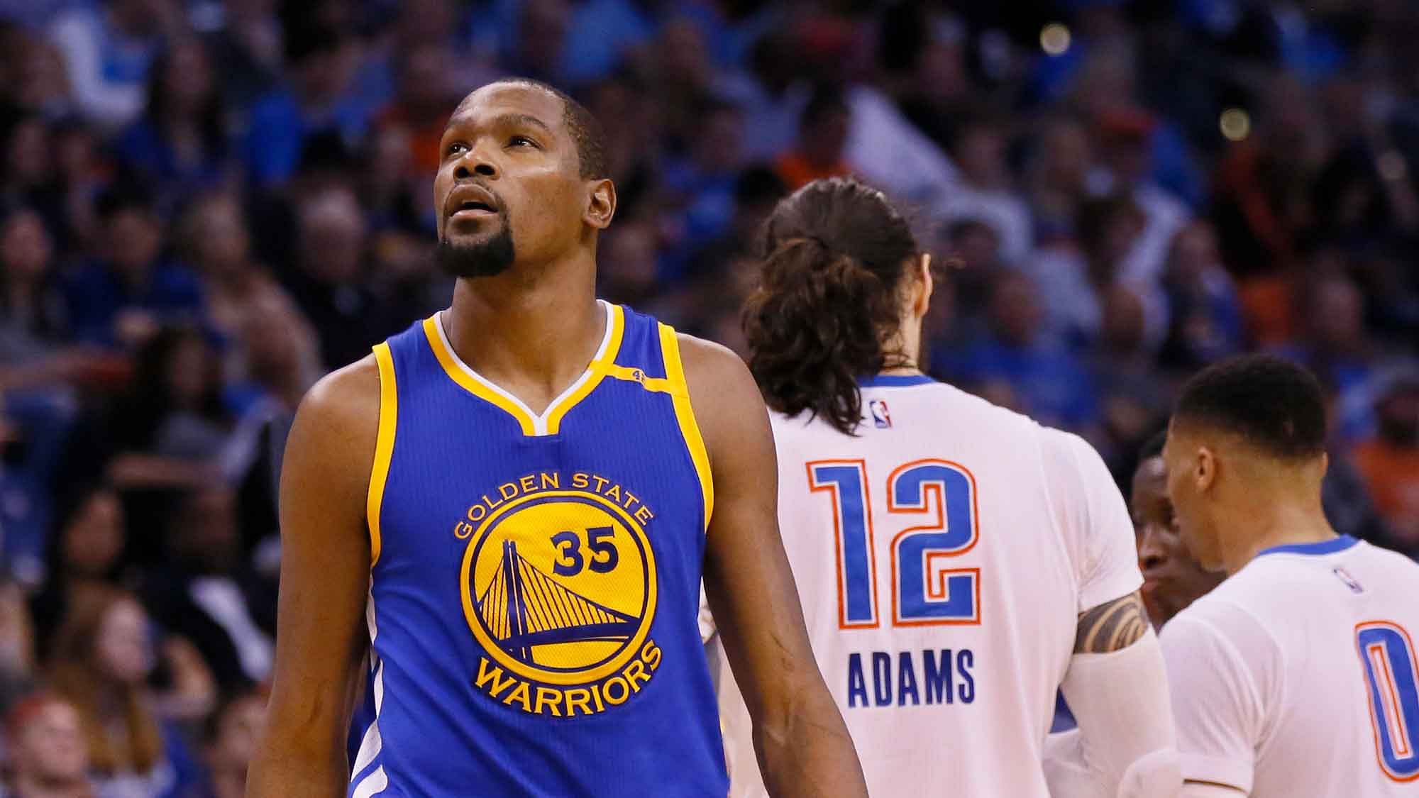Golden State Warriors forward Kevin Durant (35) walks past former teammates Oklahoma City Thunder center Steven Adams (12) and guard Russell Westbrook (0) in the second quarter of an NBA basketball game in Oklahoma City, Saturday, Feb. 11, 2017. (AP Photo/Sue Ogrocki)