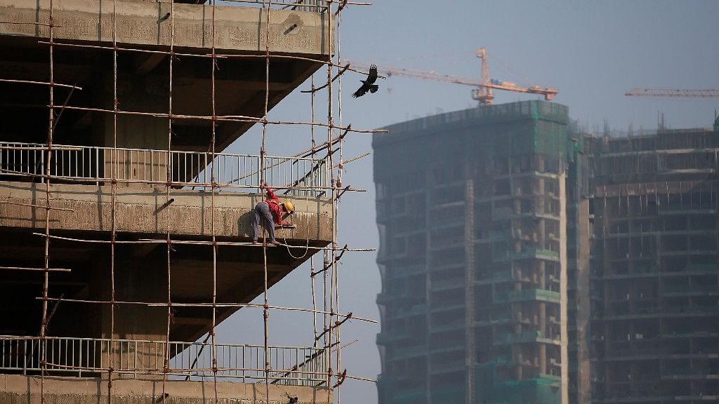 A labourer stands on wooden scaffolding as he works at the construction site of a commercial building in Mumbai’s central financial district on 16 January 2015. (Photo: Reuters)