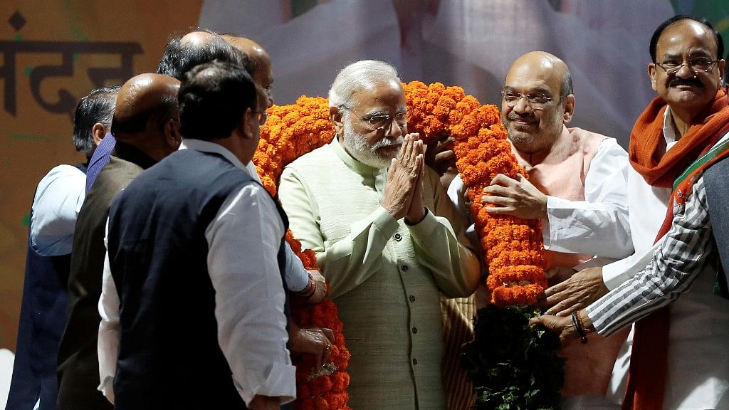India’s Prime Minister Narendra Modi is being garlanded by party leaders after victory at Uttar Pradesh polls. (Photo: Reuters)