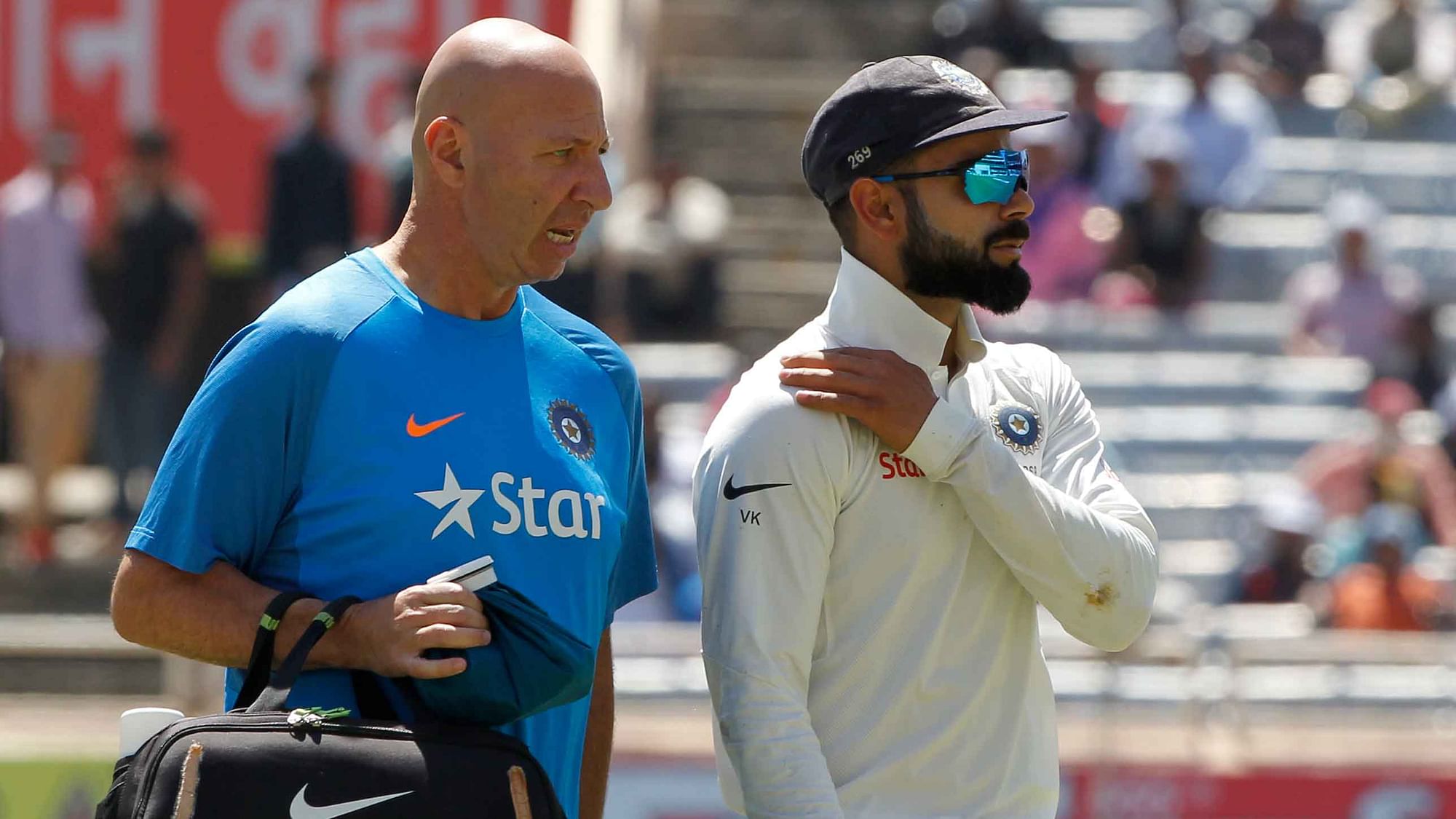 Virat Kohli walks off the field with the physio after injuring his shoulder. (Photo: BCCI)
