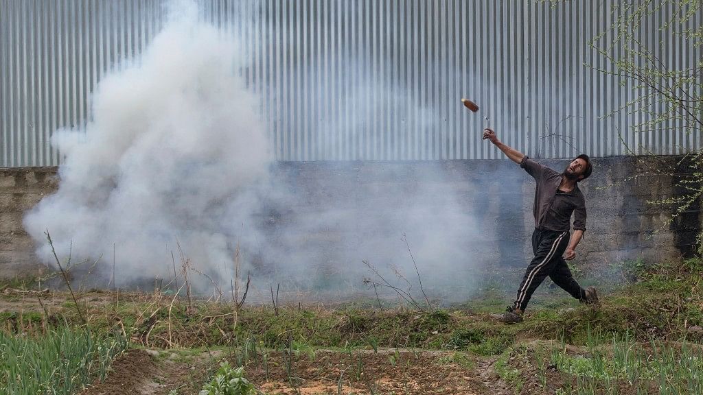 A Kashmiri protester throws a glass bottle at Indian security forces during a protest near the site of a gun battle in Chadoora town, about 25 kilometres south of Srinagar. (Photo: AP)